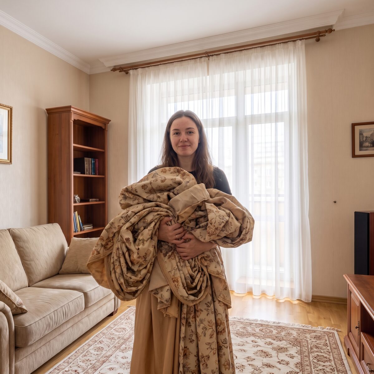 Женщина держит светлый ламбрекен в комнате
